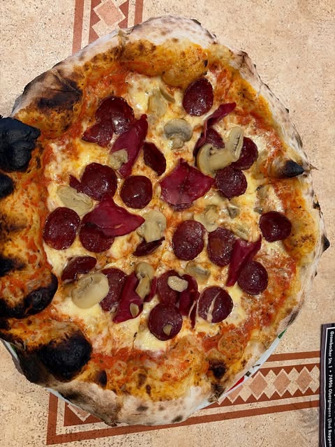 Holzofenpizza mit Salami und Champignons